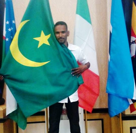 صورة للبطل الموريتاني في لعبة الشطرنج سيدي ولد بيديا وهو يحمل العلم الموريتاني(السراج)