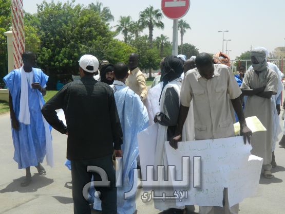 أحد المشاركين يعرض لافتة كتبت باليد 