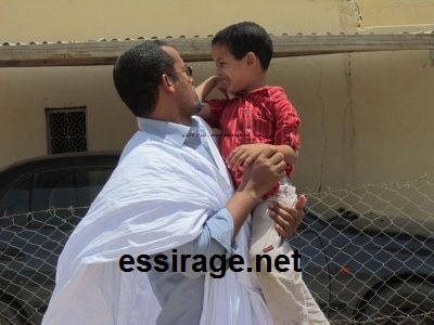 الطفل الوديع خالدا ضاحكا من اصطدام برأس قريبه الذي يحمله (خاص للسراج)