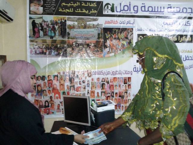 جانب من توزيع الكفالات المخصصة للأيتام على ربات الأسر المكفولة (السراج)