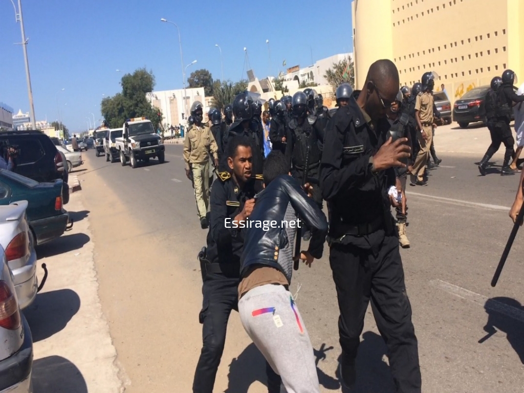 أحد الضباط يقمع أحد الطلاب