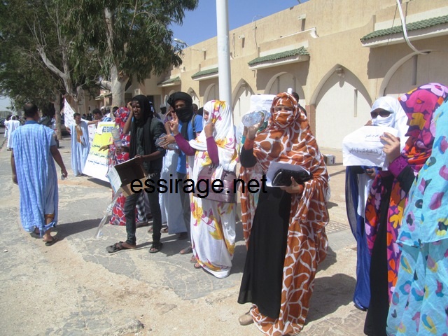 سيدات يرفعن علب مياه فارغة أثناء ترديد الشعارات